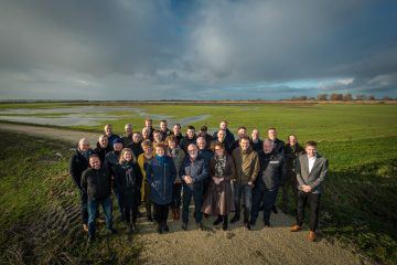 Groepsfoto delegatie Flevoland in weiland.