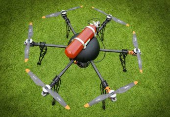 Een drone, die kan vliegen op waterstof, zweeft boven een grasveld.