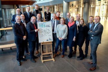 De partijen achter de RES staan om een bord met handtekeningen.