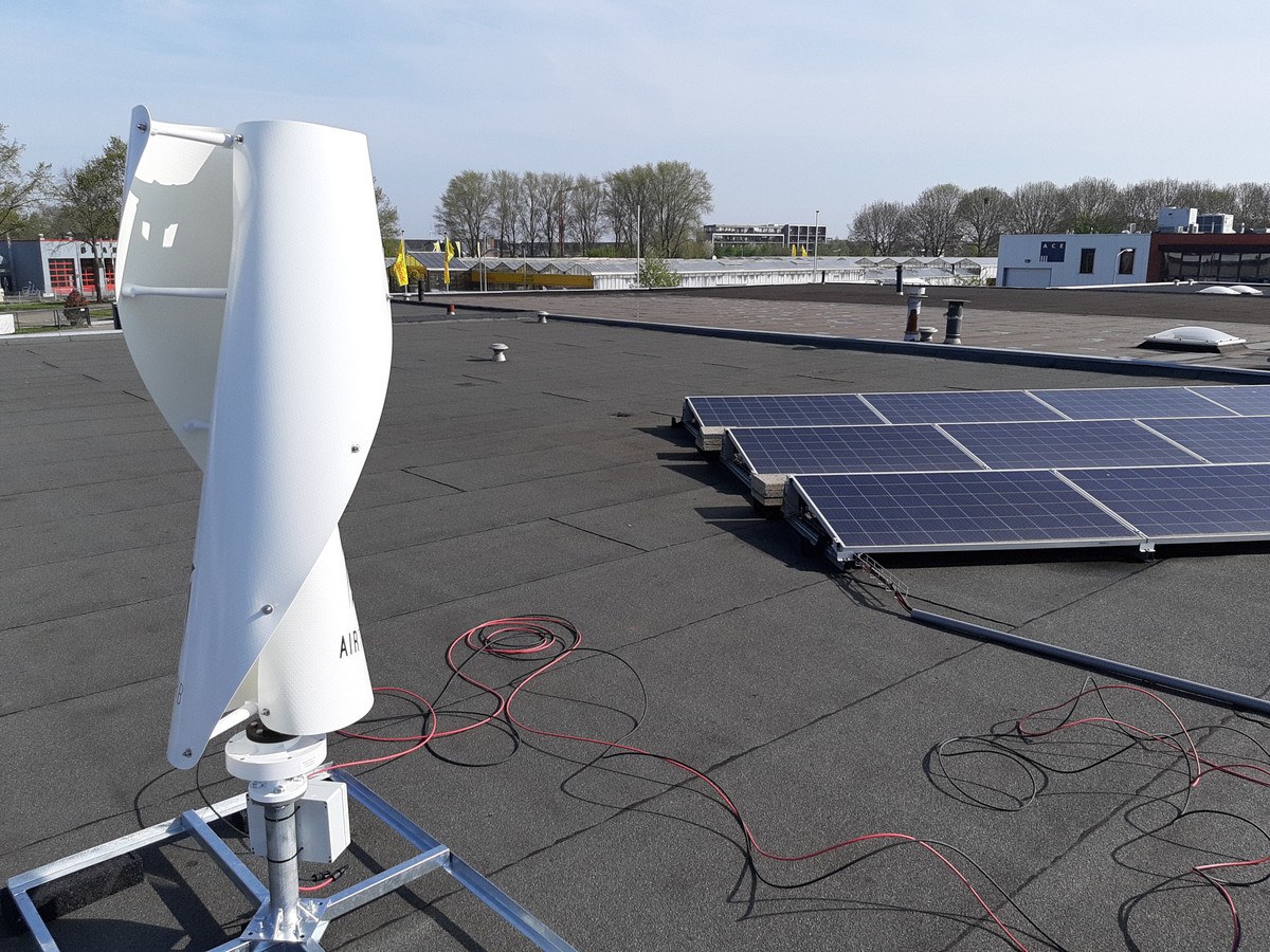 een dak met kleine windmolen en zonnepanelen