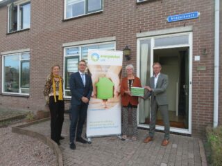 De eerste bespaardoos wordt overhandigd aan mevrouw De Mooij.