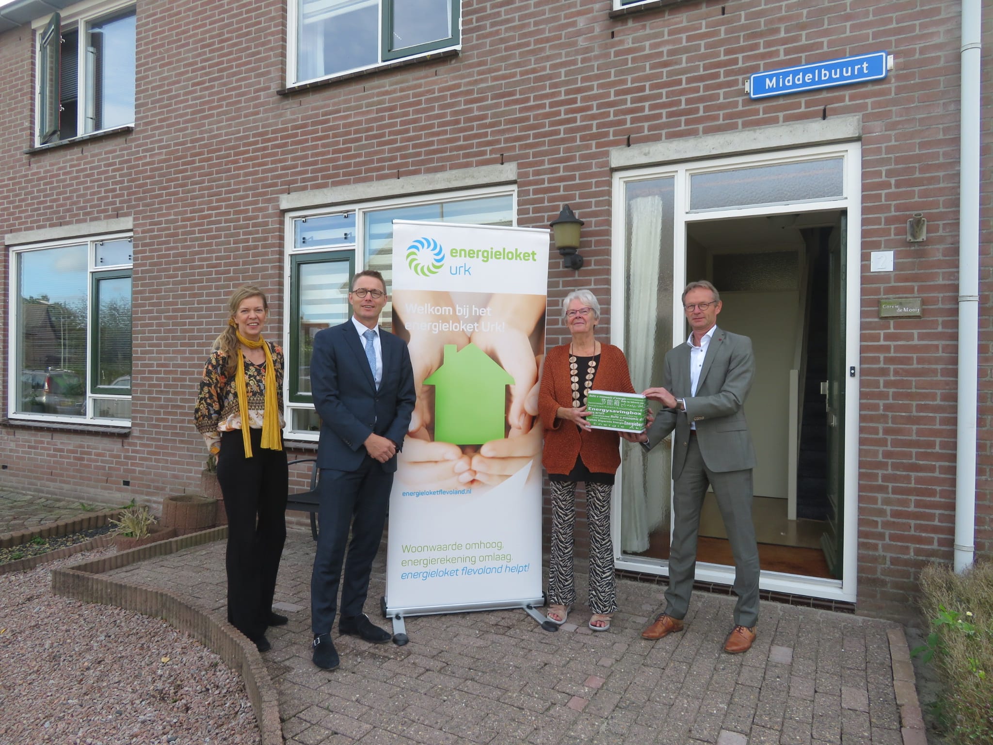 De eerste bespaardoos wordt overhandigd aan mevrouw De Mooij.