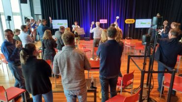 Publiek kijkt toe bij de presentatie van