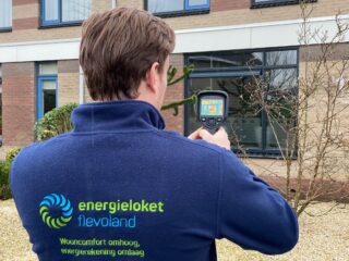 Medewerker van het Energieloket doet een warmtescan van een huis.
