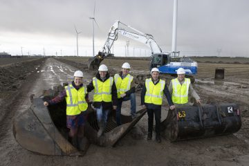 De initiatiefnmers samen met de gedeputeerde en wethouder poseren voor een graafmachine.